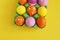 Easter holiday. Easter eggs in a tray for eggs. Eggs on a stand. Yellow background.