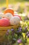 Easter holiday.Easter eggs in a yellow basket in purple spring flowers on a blurred spring background in the morning