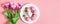 Easter holiday pink table setting with eggs, rabbit and a bouquet of tulips. Banner. Copy space, top view