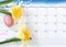 Easter holiday reminder marked on calendar with yellow daffodils and colorful egg