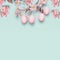 Easter layout with hanging pastel pink eggs and spring blossom at light at blue turquoise background