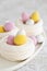 Easter meringue nests with colorful sweet eggs on plate.