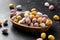 Easter mini eggs, chocolate candy in wooden bowl