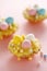 Easter mini tarts decorated with frosting and marzipan eggs in pastel colors