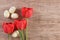 Easter natural background with red tulip decorated with Easter Eggs on light brown. Text space, top view