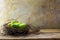 Easter nest with green colored eggs on rustic wood planks against a rural vintage wall with copy space