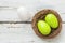 Easter nest with green easter eggs on a wooden background