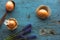 Easter orange eggs on a blue wooden old background. Egg in a spoon and flowers