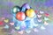 Easter. Painted eggs of yellow, pink, purple, green, turquoise pearl color in blue packaging on a holographic rainbow background