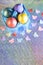 Easter. Painted eggs of yellow, pink, purple, green, turquoise pearl color in blue packaging on a holographic rainbow background