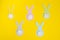 Easter paper bunnys isolated on yellow background, concept: childrens crafts for Easter, top view