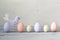 Easter pastel colored eggs and purple hand made bird on a light wooden background