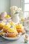 Easter pastry lemon cupcakes with yellow buttercream frosting decorated with sprinkles and chocolate eggs. Festive table setting