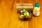 Easter pattern design giftbox craft brown pair eggs green yellow candy dragee wooden background