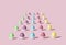 Easter pattern of pastel colored eggs that looks like tasty cookies. Colorful concept of cupcakes on pink background