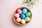 Easter picture, multi-colored eggs in a wooden plate, on a pink background