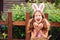 Easter portrait of happy child girl in funny bunny ears playing egg hunt outdoor