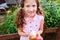 Easter portrait of happy child girl in funny bunny ears playing egg hunt outdoor