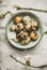 Easter quail eggs and blooming almond tree branches, vertical composition