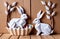 Easter rabbits in a basket surrounded by painted eggs and twigs of flowering willow.