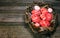 Easter red eggs with folk white pattern inside bird nest on right side of rustic wood background. Ukrainian traditional eggs