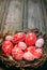 Easter red eggs with folk white pattern inside bird nest on rustic wood background. Ukrainian traditional eggs