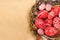 Easter red eggs with folk white pattern inside bird nest on sheet of paper background. Top view. Ukrainian traditional eggs