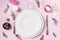 Easter romantic dinner. Elegance table setting spring pink flowers on pink linen tablecloth. Top view.