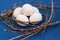 Easter rustic or scandinavian composition on classic blue background. A nest made of willow branches with white egg. Farming and