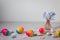 Easter scene with rainbow eggs and spring flowers in vase