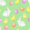 Easter seamless pattern. Cute hare, yellow funny chickens and colored eggs on green background.