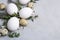 Easter spring decorative composition with easter quail, chicken eggs and leaf sprigs of eucalyptus. On a gray concrete background