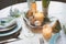 Easter and spring festive table decorated in blue and white tones in natural rustic style, with eggs, bunny, fresh flowers