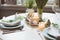 Easter and spring festive table decorated in blue and white tones in natural rustic style, with eggs, bunny, fresh flowers