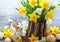 Easter still life with bouquet of daffodils in vase from bark of wood, Easter eggs and cute rabbit