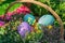 Easter street decoration. Wicker basket full of painted easter eeggs, cake and flowers