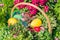 Easter street decoration. Wicker basket full of painted easter eeggs, cake and flowers