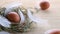 Easter symbol. Natural colour eggs in basket with spring tulips, white feathers on wooden table background in Happy Easter decorat