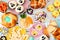 Easter table scene with a selection of breads, desserts and treats, above view over a white wood background