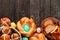 Easter table scene with a selection of fresh breads, above view bottom border over a wood background