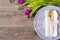 Easter table setting, flatlay - wedding party, event decoration. Purple dishes and a gold fork and a spoon on a wooden background