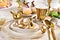 Easter table setting with golden color decors on the plate and cutlery