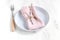 Easter table setting idea, minimal decoration - pink napkin, fork, willow banch, white wooden table