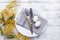 Easter table setting. White eggs, napkin on a plate, mimosa flowers, fork, knife on a wooden table