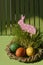 Easter toy rabbit in a basket with colorful painted eggs Vertical