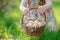 Easter tradition: little girl holds basket, searching for eggs on green meadow