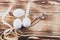 Easter white eggs are tied with a ribbon with a willow for the Easter holiday on a brown wooden natural table