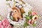 Easter wicker basket with floral decoration and cute bunny figurine
