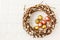 Easter willow wreath and quail Easter eggs on white tablecloth. Top view