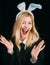 Easter woman. Portrait of a happy woman in bunny ears winking. Closeup of winking Easter bunny girl face. Give a wink